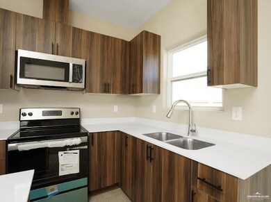 Kitchen featuring appliances with stainless steel finishes, light countertops, a sink, and modern cabinets