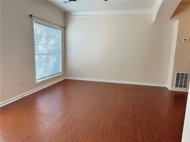 Empty room featuring dark wood finished floors, ornamental molding, and baseboards