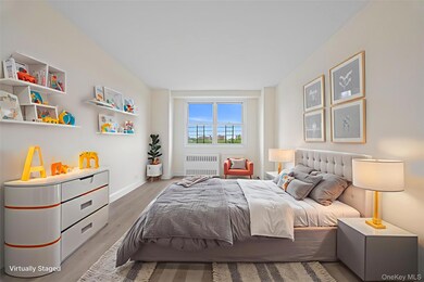 Bedroom with wood finished floors and radiator heating unit