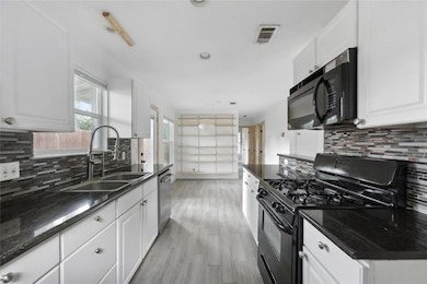 Kitchen featuring black appliances, tasteful back