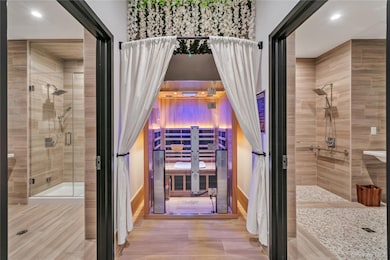 Bathroom with recessed lighting, a stall shower, baseboards, and wood finished floors