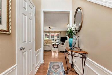 Hall with light wood-type flooring and wainscoting