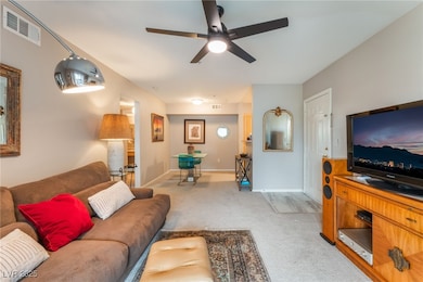 Living room featuring a ceiling fan, light colored