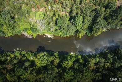 Aerial view of property's location with a large body of water
