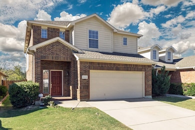 Traditional-style house featuring brick siding, roof with shingles, a front lawn, concrete driveway, and a garage