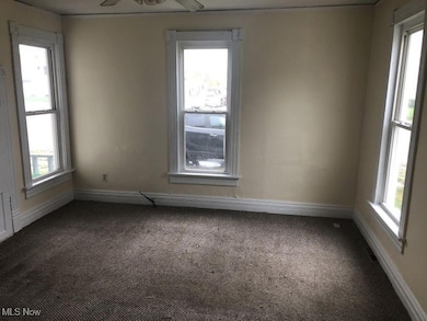Spare room with dark colored carpet