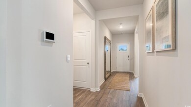 Corridor featuring dark wood-style flooring and baseboards