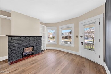 Virtually Staged Unfurnished living room featuring plenty of natural light, built in shelves, light wood-type flooring, and baseboards