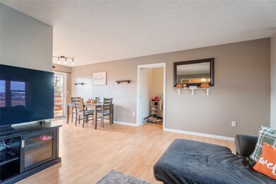 Living room featuring a textured ceiling, light wood-style flooring, and track lighting