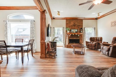 Living room featuring plenty of natural light, ornamental molding, light wood-style flooring, ceiling fan, and a textured ceiling