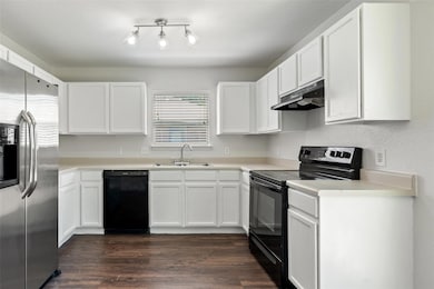 Kitchen featuring a sink, black appliances, white