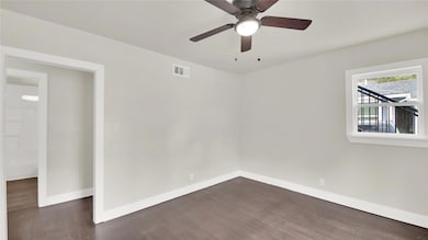 Unfurnished room with dark wood-style flooring and a ceiling fan