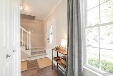 Foyer entrance with dark wood-style floors, stairw