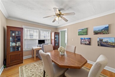Dining area with crown molding, light hardwood flooring, and ceiling fan