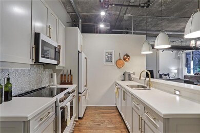 Kitchen with high end appliances, a peninsula, light wood-style floors, pendant lighting, and backsplash