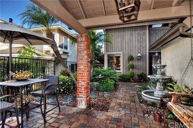 Gated front courtyard w/pavers, fountain, swing