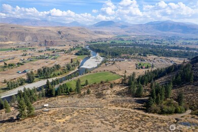 Birds-eye view shows outbuilding, yurt & privy to the far left, fenced garden to far right.