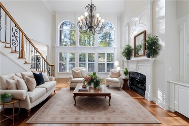 Living room with a chandelier, a towering ceiling,