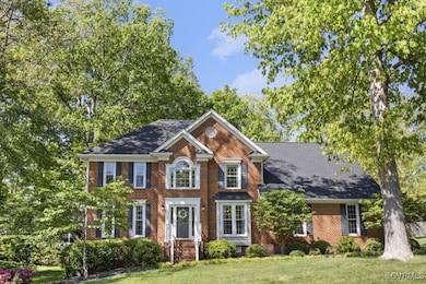 Colonial home featuring a front lawn and brick sid