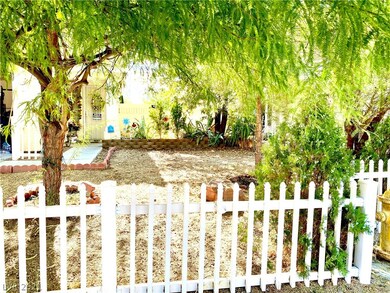 The front yard is gated and fenced with white pick