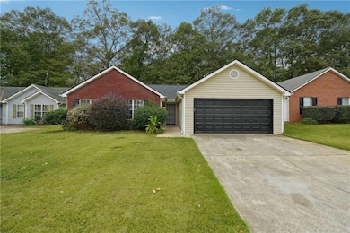 Ranch-style house with a garage and a front lawn