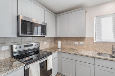 Kitchen featuring  backsplash, white cabinetry, si