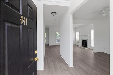Foyer with wood finished floors, a ceiling fan, and a high end fireplace