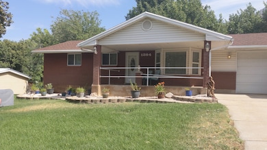 View of front of house featuring a front lawn, a porch, roof with shingles, and an attached garage