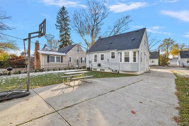 Rear view of property with a shingled roof, a patio, and a lawn