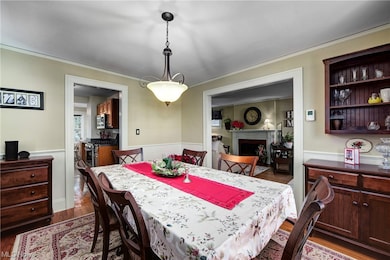 Dining area featuring dark hardwood / wood-style flooring, built in features, and ornamental molding