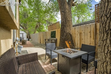 View of patio with an outdoor fire pit, a fenced backyard, a shed, and an outdoor structure