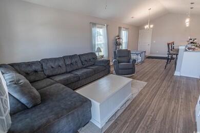 Living area featuring baseboards, lofted ceiling, 