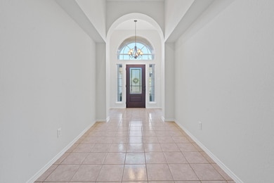 Foyer entrance featuring a chandelier, light tile