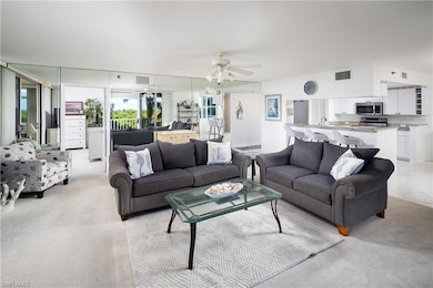 Living area with a ceiling fan and light colored carpet