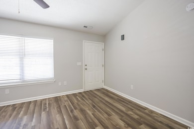 Empty room with a textured ceiling, ceiling fan, w