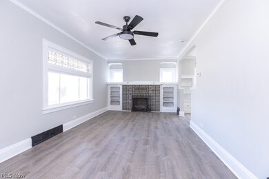 Unfurnished living room featuring a fireplace, ornamental molding, ceiling fan, and hardwood / wood-style floors