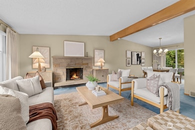 Main living room is light and bright, complete with a cozy fireplace.  The blue carpet has been protecting the original oak hard wood floors that run throughout the entire upstairs!