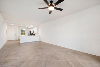 Unfurnished living room with ceiling fan and light tile floors