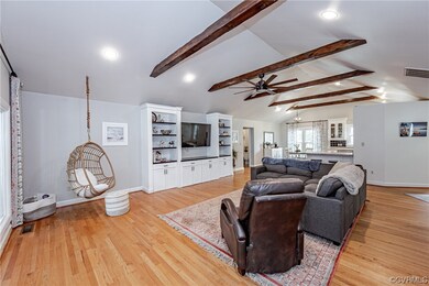 Hardwood floored family room with a ceiling fan, b