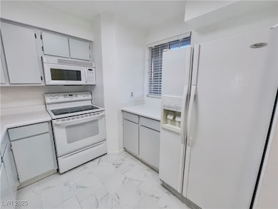 Kitchen with light countertops, white appliances, marble finish floor, and gray cabinets