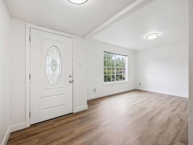 Entrance foyer featuring wood finished floors and beam ceiling