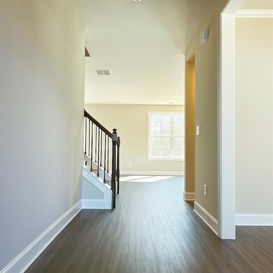 Hallway featuring stairway, visible vents, baseboa