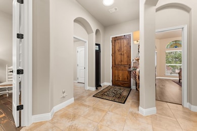 Entrance foyer featuring arched walkways, light t