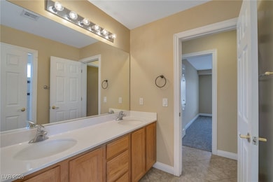 Full bath with double vanity, visible vents, tile
