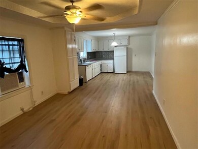 Kitchen featuring white appliances, white cabinetry, a ceiling fan, light wood finished floors, and pendant lighting