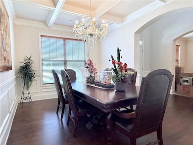 Dining space with dark wood-style flooring, arched
