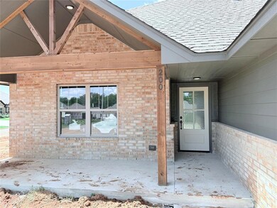 Entrance to property featuring brick siding and roof with shingles