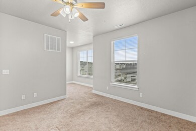 Unfurnished room with light carpet, a textured ceiling, and a ceiling fan