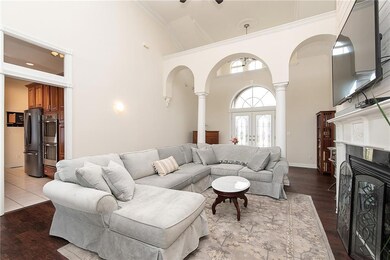 The great room has two-story ceilings, custom ceiling trim, recessed lighting, double crown molding, luxury vinyl plank flooring. Gas log fireplace is newly designed with white wash shiplap, custom marble surround and elegant mantle detail.