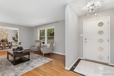 Foyer entrance with a chandelier and white oak flooring.